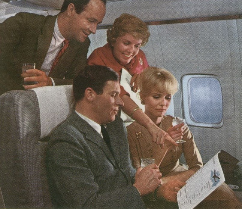 1959 First Class customers review the dinner menu on a Pan Am Boeing 707 jet.